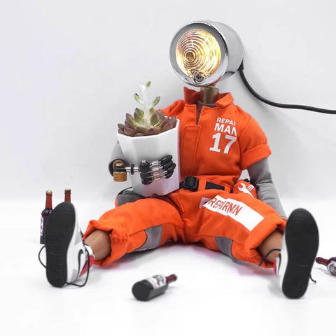 Humanoid cyberpunk desk lamp in orange clothing sitting on the floor